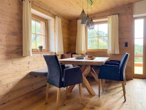 una sala da pranzo con un tavolo e sedie blu di Chalet Tuxer ad Achenkirch