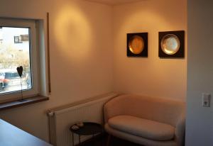 Una sala de estar con una silla y una ventana. en Ferienwohnung Schlossblick in Giengen Burgberg, en Giengen an der Brenz 13 fotos más