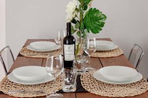 a wooden table with a bottle of wine and glasses at Lucky Home Near Train Station and City center in Verona