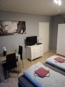 een slaapkamer met 2 bedden, een bureau en een tafel bij Stadtnah an der Förde 65 U in Flensburg