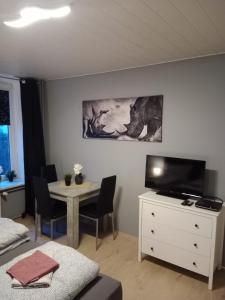 een woonkamer met een tafel en een televisie bij Stadtnah an der Förde 65 U in Flensburg