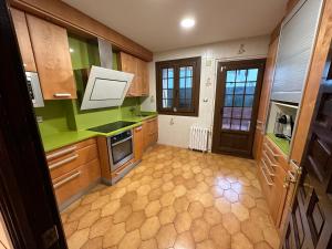 a kitchen with green counter tops and wooden cabinets at Apartamento Plaza del Rey in Santillana del Mar