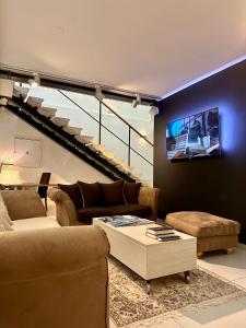 ein Wohnzimmer mit Sofas und einem TV an der Wand in der Unterkunft VENEZIANA Boutique Hotel Superior in Koper