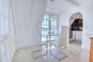 Abaluga 6A في فينينغستيدت: غرفة طعام مع طاولة زجاجية وكراسي بيضاء