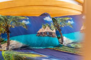 a bed with a pillow with a painting of a resort at Apartamento en el Cabo roig in Orihuela +18 photos