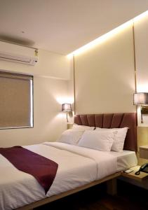 a bedroom with a large white bed with two lamps at Vishal Hall in Mumbai