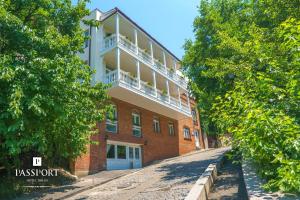 a brick building with a balcony on the side of it at Hotel Passport Tbilisi in Tbilisi City