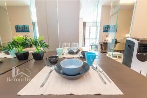 a table with a bowl and plates and wine glasses at Dorsett Residences Sri Hartamas in Kuala Lumpur