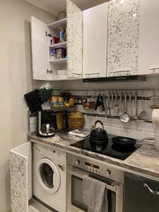 a kitchen with a stove and a washing machine at Frendly Flat Free Parking Kitchen Equipment Cosy in Rīga