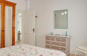1 dormitorio con 1 cama y vestidor con espejo en Apartamento La Fuente, en Conil de la Frontera
