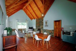 cocina y sala de estar con mesa de madera y sillas en Spion Kop Lodge, en Winterton