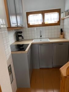 una pequeña cocina con fregadero y encimera en Chalet mit Blick auf das Kitzbühler Horn en Kirchdorf in Tirol