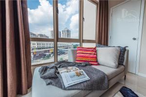 a living room with a couch and a large window at Dorsett Residences Sri Hartamas in Kuala Lumpur