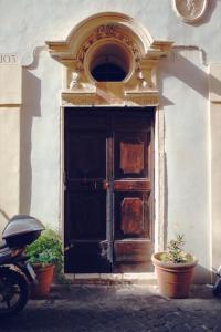 eine alte Holztür mit Pflanzen vor einem Gebäude in der Unterkunft Palazzo Lupardi Relais in Rom