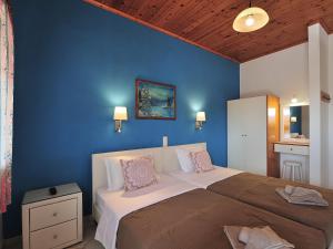 - une chambre avec un grand lit et un mur bleu dans l'établissement Vista Mare Skiathos, à Kolios