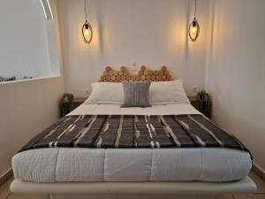 a large bed in a room with two lights at Amerisa Suites & Villa in Fira