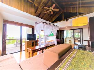 a bedroom with a bed and a desk and a tv at LiVEMAX Amms Hotels Canna Resort Villa in Ginoza