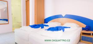 a bed in a hotel room with blue robes on it at Penzion DIAMANT in Primorsko