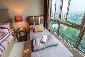 um quarto com uma cama e uma cadeira em frente a uma janela em Dorsett Residences Sri Hartamas em Kuala Lumpur