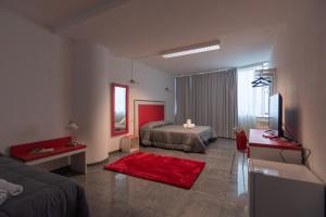 a bedroom with a bed and a television and a red rug at Delta Rooms in Olbia