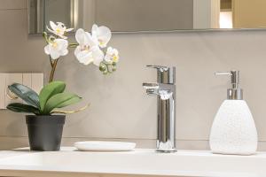 a bathroom sink with a plant and a faucet at Porta Palio Luxury Apartment in Verona
