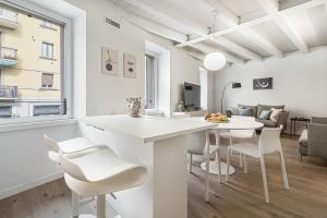 een keuken en een woonkamer met een tafel en stoelen bij Porta Palio Luxury Apartment in Verona