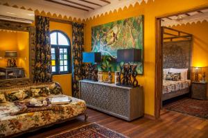 a bedroom with yellow walls and a large mirror at Kholle House in Zanzibar City