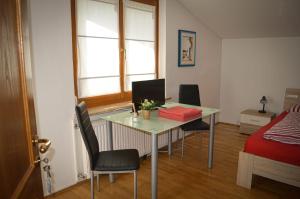 Zimmer mit einem Tisch, Stühlen und einem Bett in der Unterkunft Villa Viola in Moosburg