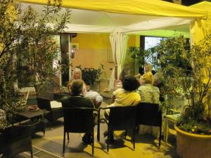 un grupo de personas sentadas en una mesa en Hotel Il Ponte, en Cecina