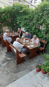 a group of people sitting at a table eating at Къща за гости ДИАМАНТ in Primorsko