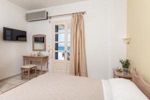 um quarto branco com uma cama e uma janela em Orkos View em Mikri Vigla