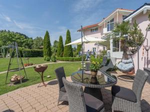 eine Terrasse mit einem Tisch und Stühlen sowie ein Haus in der Unterkunft Wellnesshof Blenk in Wertach