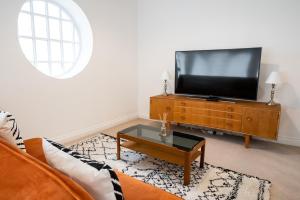 a living room with a flat screen tv on a dresser at The Amazing Triplex in Sheffield
