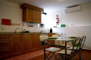 a kitchen with a table and chairs and a sink at Cantinho Santiago in Belmonte