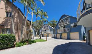 una fila de edificios de apartamentos con palmeras y una entrada en Rainbow Getaway Holiday Apartments, en Rainbow Beach