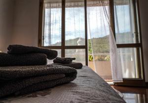 a bed with towels on it with a window at Agriturismo La Rocca in San Bartolomeo al Mare