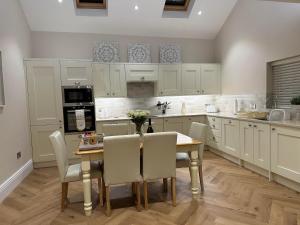 a kitchen with a table and chairs and a kitchen with white cabinets at Strother's Townhouse in Berwick-Upon-Tweed