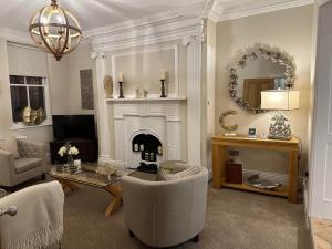 uma sala de estar com lareira e uma mesa e cadeiras em Strother's Townhouse em Berwick-Upon-Tweed
