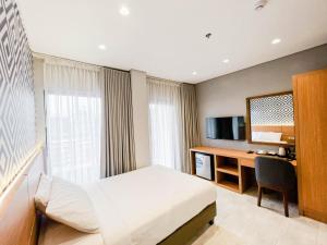 a hotel room with a bed and a desk at The Manaoag Hotel in Manaoag