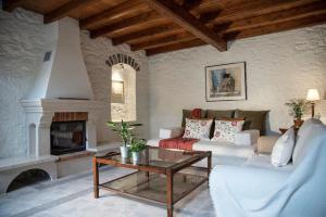 a living room with a couch and a fireplace at Mansion Eugenie in Hydra