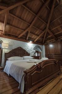 a large bed in a room with a wooden ceiling at Mansion Eugenie in Hydra