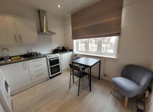 a small kitchen with a table and a chair at Quiet Terraced House in Bristol