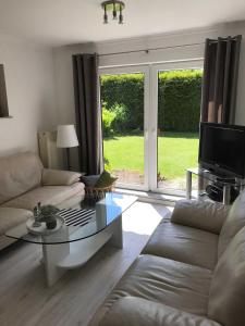 a living room with a couch and a glass table at Ferienhaus Eldena Greifswald Steffi Fasten in Eldena