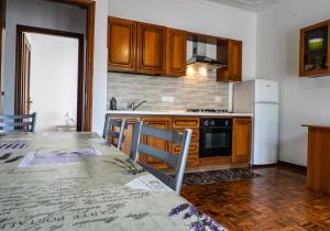 a kitchen with a table and a stove and a refrigerator at Agriturismo La Rocca in San Bartolomeo al Mare