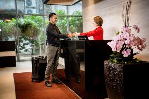 a man and a woman shaking hands at a desk at ASIA MELAKA HOTEL managed by The Straits Hotel & Suites 马六甲亚逸酒店 in Melaka +83 photos