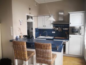 cocina con encimera azul y 2 sillas en Les 5 balcons, en Le Tréport