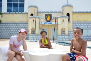 kobieta i dwoje dzieci siedzących przed zamkiem w obiekcie Princess Family Club Riviera - All Inclusive w mieście Playa del Carmen