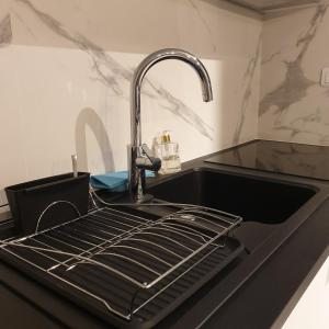 a black kitchen sink with a faucet and a sink at LE MONTI appartement proche MEETT, Aéroport Blagnac, Airbus, Golf international de Seilh in Mondonville