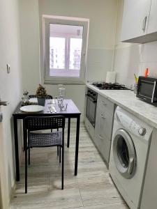 a kitchen with a table and a washing machine at Garsoniera 2 Mega Mall in Bucharest
