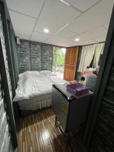 Ban Lam Ru (1)的住宿－Baan Tarn Naam，一间小卧室,配有一张床和一张桌子